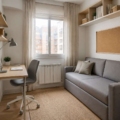 Habitación pequeña con sofá cama cerrado y escritorio de poco fondo